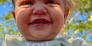 Elliana joined the competition — help win amazing prizes! toddler, child, smile, face, outdoor, sunlight, blue_sky, green_leaves, nature, happy, portrait, baby, person, head, clothing, daylight, cute, expression, closeup, young