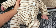 Andreas participe au concours pour gagner de l'argent avec cette photo : baby, infant, striped_clothing, pacifier, hand, tattoo, person, man, blurred_background, indoor, fabric, texture, holding, cute, expression, wide_eyes, pajamas, bedspread, pattern, cozy