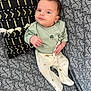 Andreas participe au concours pour gagner de l'argent avec cette photo : baby, infant, child, couch, pillow, patterned_fabric, green_clothing, white_pants, toy, hand, face, eyes, hair, sitting, indoor, cute, comfort, curious, soft_lighting, home
