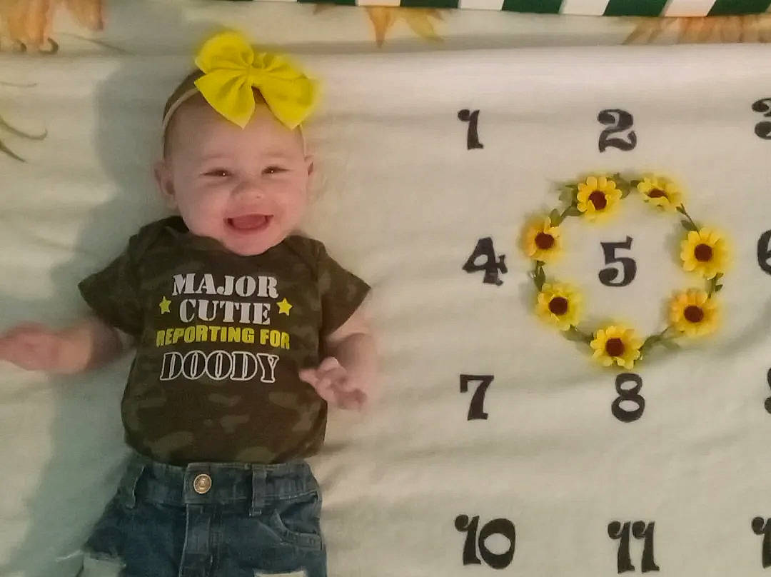 Joanna is registered to the contest to win money with this photo: baby, baby_toddler_clothing, cap, child, circle, facial_expression, fashion_accessory, font, fun, happy, headwear, jewellery, joy, pattern, person, product, room, sleeve, smile, t_shirt