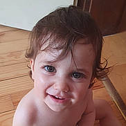 Ysée participe au concours pour gagner de l'argent avec cette photo : baby, child, closeup, curly_hair, cute, eyes, face, floor, hair, happy, indoors, looking_up, natural_light, person, portrait, skin, smile, toddler, wooden_floor, young_child