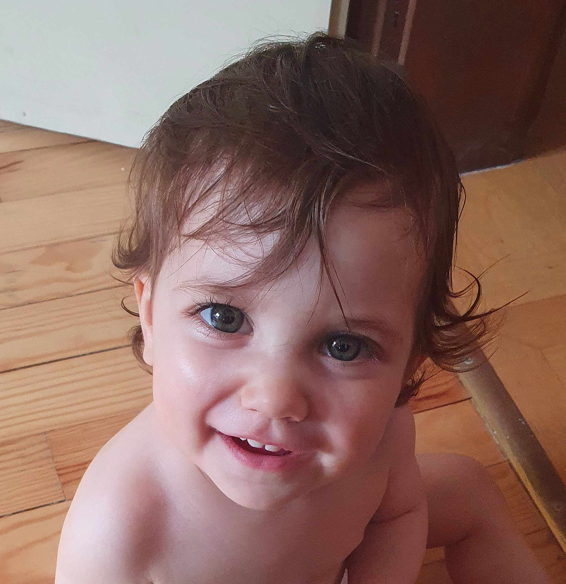 Ysée participe au concours pour gagner de l'argent avec cette photo : baby, child, closeup, curly_hair, cute, eyes, face, floor, hair, happy, indoors, looking_up, natural_light, person, portrait, skin, smile, toddler, wooden_floor, young_child
