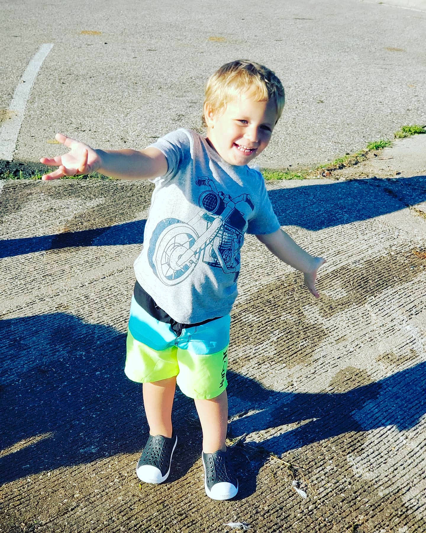 Caysen is registered to the contest to win money with this photo: asphalt, blue, child, fun, joy, leisure, person, plant, play, public_space, recreation, shadow, shoe, standing, summer, t_shirt, toddler, vacation, walking