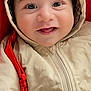 baby, child, smile, hood, jacket, blanket, face, eyes, cute, infant, warm_clothing, red_background, soft_texture, portrait, closeup, happy, cozy, young_child, person, indoor