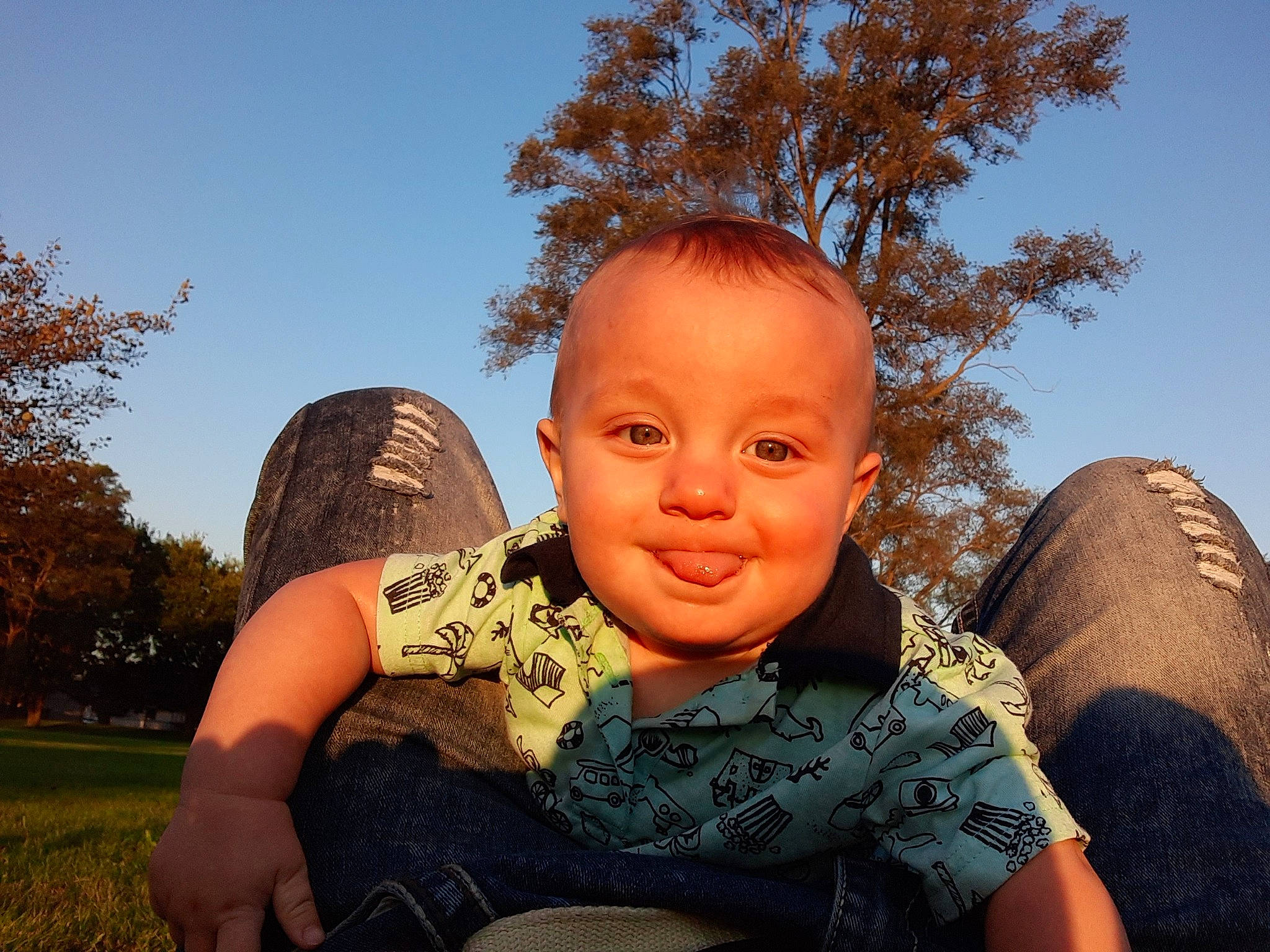 Emory is registered to the contest to win money with this photo: adaptation, baby, child, cool, face, finger, fun, grass, happy, head, joy, leaf, people, person, photography, sitting, sky, smile, toddler, tree