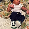 Kingston is registered to the contest to win money with this photo: baby, infant, hat, sneakers, clothing, pillow, animal_pattern, bed, blanket, white_shirt, blue_pants, newborn, cute, resting, indoor, sleepwear, child, soft_toys, fabric, laying_down