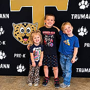 Paisley joined the competition — help win amazing prizes! children, kids, group_portrait, smiling, happy, school, pre_k, siblings, standing, indoor, backdrop, leopard, paw_prints, gold_letter, casual_clothing, t_shirt, shorts, jeans, sneakers, photography