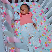 Jamaya is registered to the contest to win money with this photo: baby, crib, infant, floral, mattress, braided_bumper, pink, white, carrot_prints, clothing, sleepwear, cute, indoors, child, person, resting, smiling, head, hand, foot