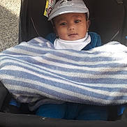 Sheik Fahad a rejoint le concours — aidez-le/la à gagner de superbes lots ! baby, child, stroller, blanket, hat, panda, face, outdoor, curious, clothing, infant, cute, portrait, young_child, seat, warm, striped_blanket, baby_boy, headwear, daylight