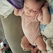 Diana is registered to the contest to win money with this photo: baby, infant, sleeping, child, striped_bodysuit, couch, blanket, stuffed_toy, portrait, indoor, nap, relaxed, lying_down, face, closed_eyes, hands, legs, home, soft_furnishings, photography