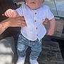 Nahël a rejoint le concours — aidez-le/la à gagner de superbes lots ! toddler, child, white_shirt, denim_pants, white_shoes, adult_hand, bench, outdoor, daylight, car, parking, wood, casual_clothing, person, baby, holding, curious, standing, urban, sunlight