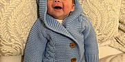 Reuben joined the competition — help win amazing prizes! baby, smiling, knitted_outfit, blue_clothing, wooden_buttons, cushion, patterned_cushion, cozy, infant, happy, indoors, soft_fabric, sitting, cute, portrait, child, warm_clothing, head, face, person