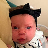Hannaya participe au concours pour gagner de l'argent avec cette photo : baby, infant, headband, black_bow, striped_clothing, pillow, closeup, face, eyes, skin, resting, indoor, soft_lighting, child, newborn, person, cute, expression, sleepwear, comfort