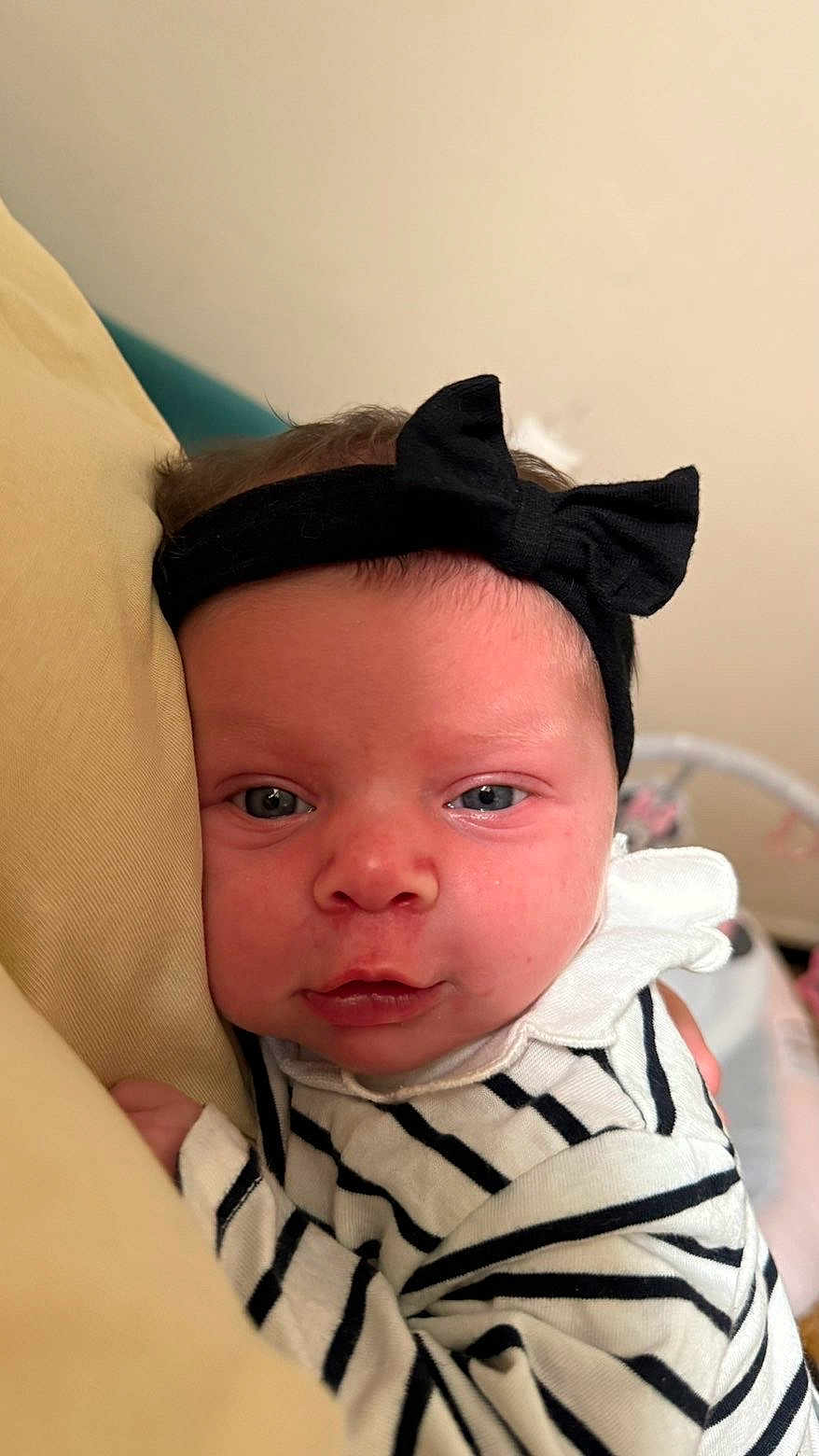 Hannaya participe au concours pour gagner de l'argent avec cette photo : baby, infant, headband, black_bow, striped_clothing, pillow, closeup, face, eyes, skin, resting, indoor, soft_lighting, child, newborn, person, cute, expression, sleepwear, comfort