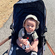 Wyatt joined the competition — help win amazing prizes! accessories, baby, bed, cap, city, clothing, face, footwear, hat, head, person, photography, portrait, road, shoe, strap, street, stroller, urban, walking