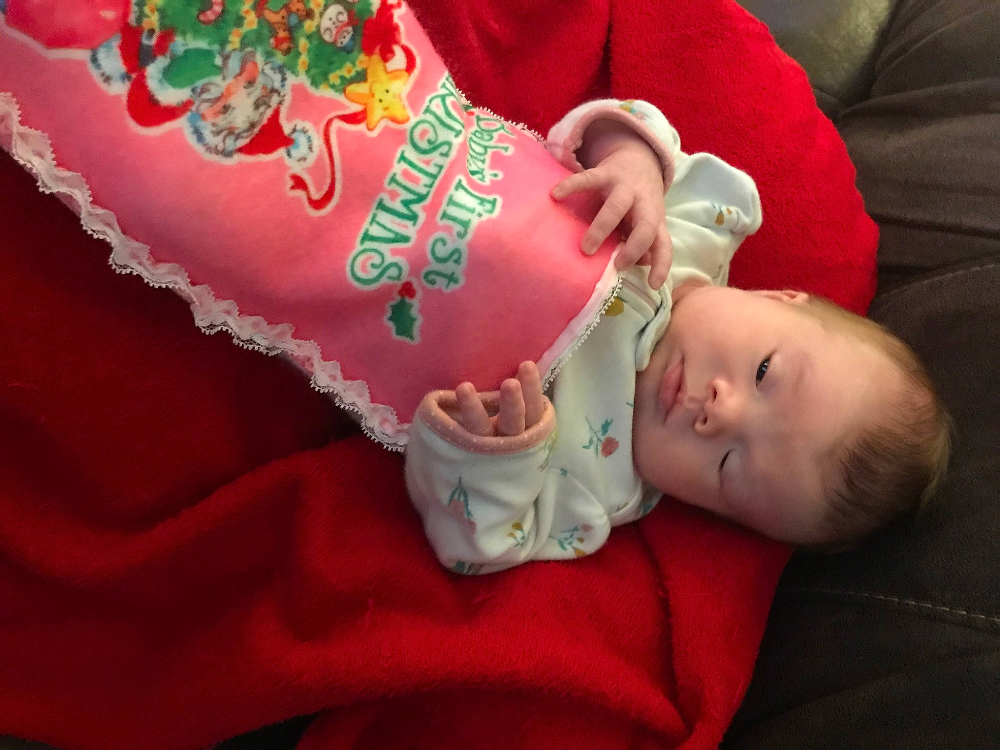 Kinlee is registered to the contest to win money with this photo: baby, baby_toddler_clothing, carmine, child, christmas, comfort, drinkware, event, flesh, font, hand, linens, nail, person, red, room, sitting, skin, sleeve, sweetness