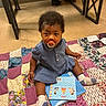 toddler, pacifier, book, patchwork_quilt, socks, indoor, child, floor, curly_hair, blue_dress, barefoot_adult, wooden_bench, tile_floor, colorful, seated, curious, young_child, cozy, playtime, home