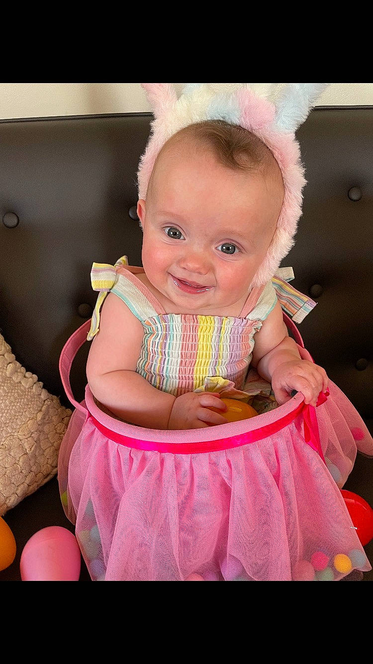 Harper is registered to the contest to win money with this photo: baby, baby_toddler_clothing, beauty, cheek, child, dress, event, flash_photography, fun, happy, joy, magenta, peach, person, pink, purple, sitting, skin, sleeve, smile