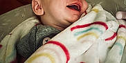 Ryleigh is registered to the contest to win money with this photo: baby, infant, blanket, rainbow_pattern, smiling, sleeping, cute, cozy, child, soft_texture, indoor, cushion, comfort, peaceful, wrapped, portrait, young, happy, face, relaxed