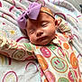 Ryleigh is registered to the contest to win money with this photo: baby, sleeping, headband, bow, onesie, smiley_face, colorful, blanket, rainbow, soft_texture, infant, peaceful, cute, child, toddler, cozy, indoors, portrait, sleep, rest