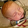 Ryleigh is registered to the contest to win money with this photo: baby, blanket, child, closeup, clothing, cozy, cushion, cute, face, indoor, infant, newborn, peaceful, portrait, red_hair, resting, sleep, sleeping, soft_lighting, toddler