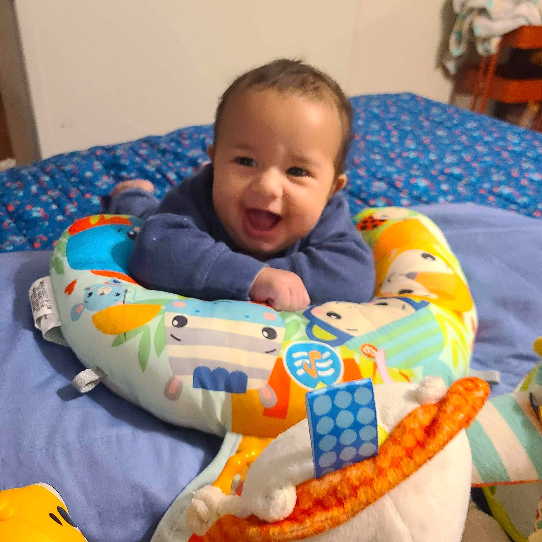 Giovanni is registered to the contest to win money with this photo: arm, baby, baby_toddler_clothing, blue, cheek, child, comfort, face, fun, happy, head, human_body, linens, mouth, orange, person, skin, sleeve, smile, toddler