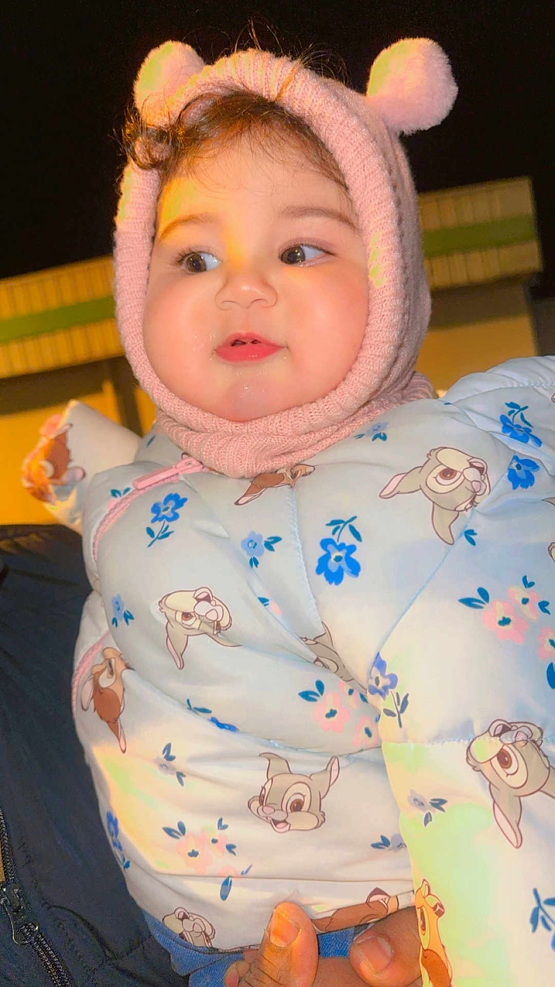 Elyn a rejoint le concours — aidez-le/la à gagner de superbes lots ! baby, child, cute, winter_clothing, knit_hat, pom_poms, jacket, cartoon_print, blue, pink, face, hand, outdoor, night, warm, smile, portrait, person, infant, holding