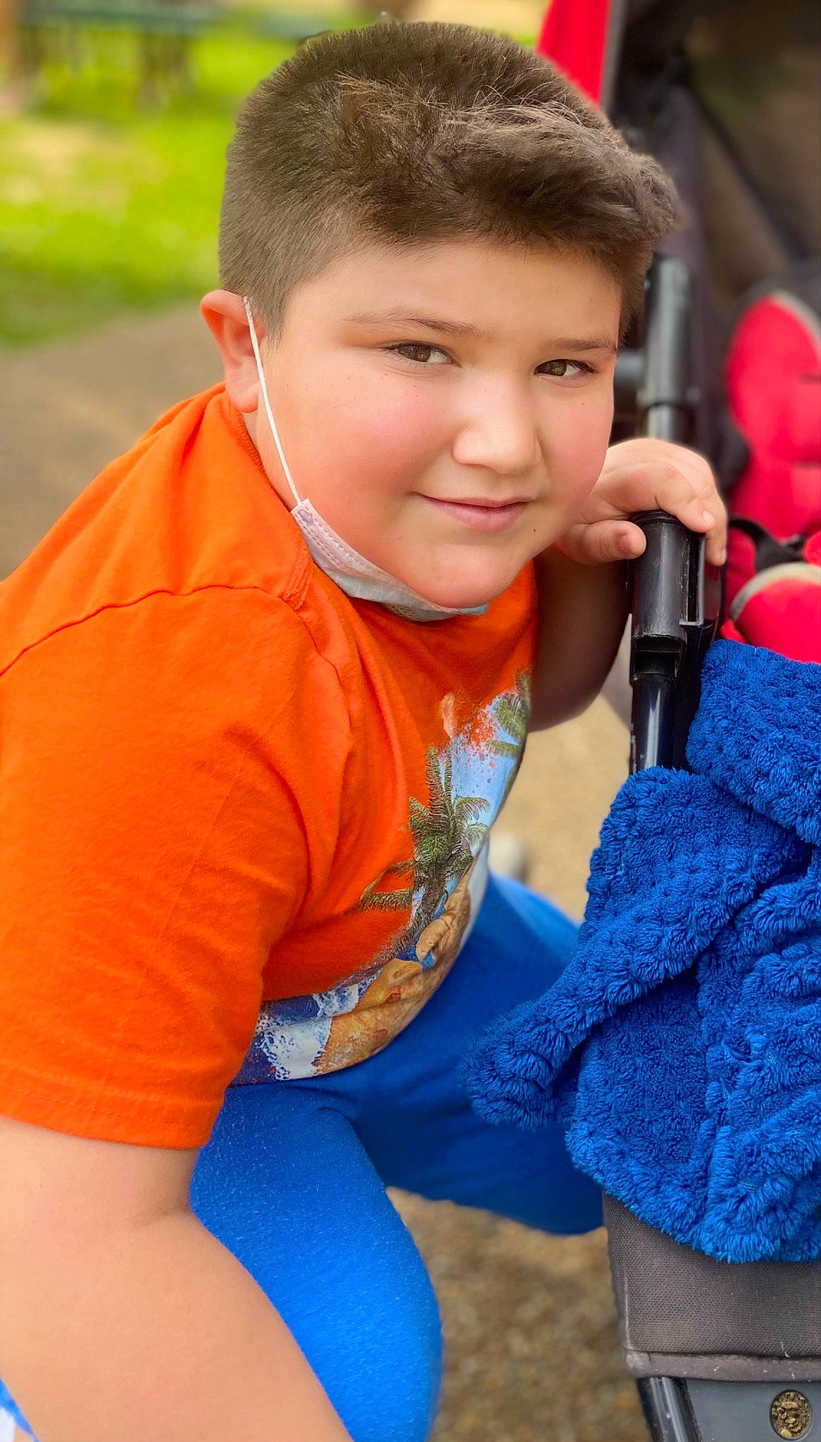 Marlon joined the competition — help win amazing prizes! blue, child, cool, electric_blue, finger, fun, grass, happy, joy, leisure, neck, orange, person, personal_protective_equipment, play, recreation, red, shoulder, sitting, sleeve