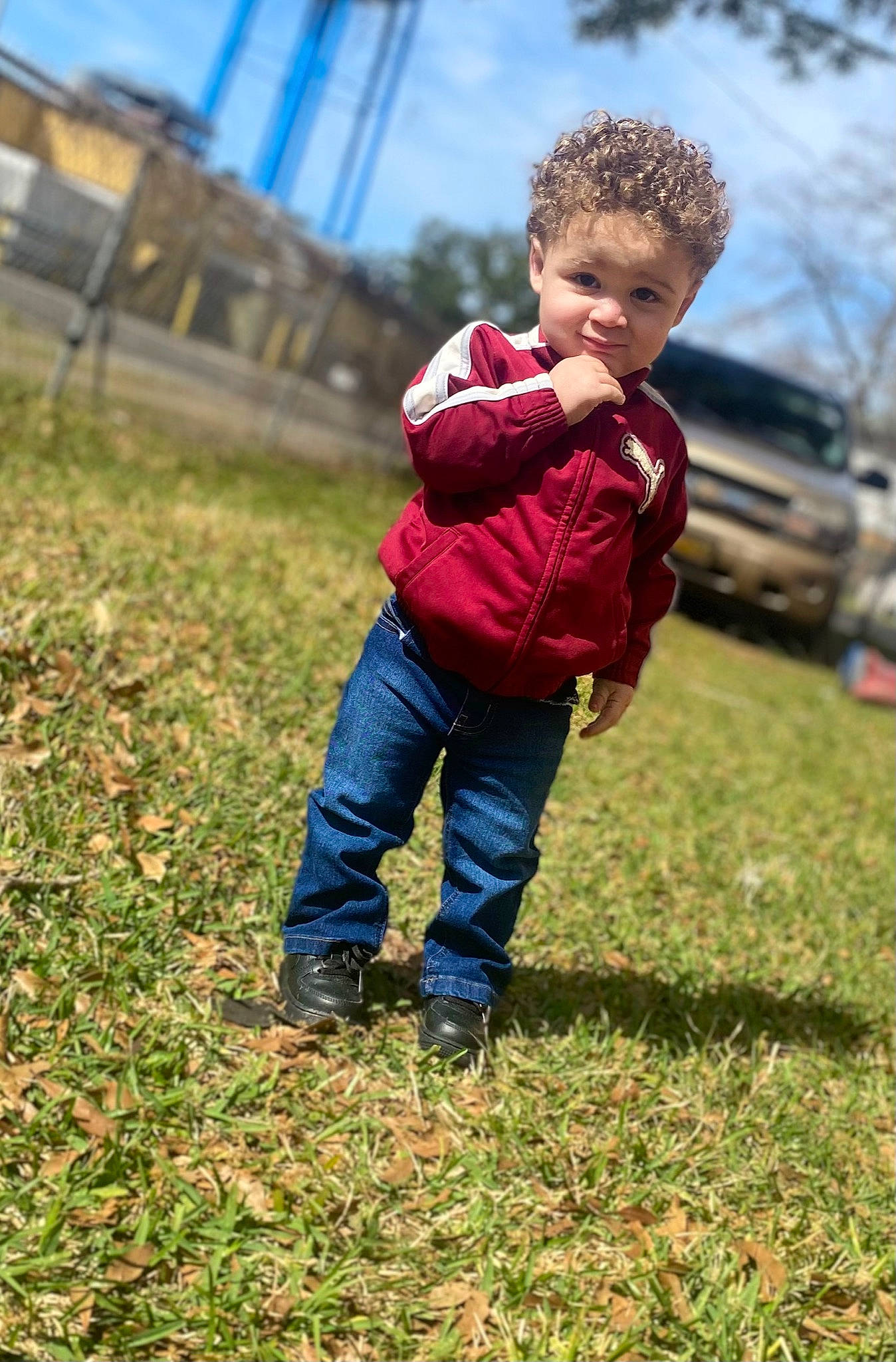 Khylan is registered to the contest to win money with this photo: boot, denim, fun, gesture, grass, grassland, happy, jacket, jeans, landscape, leisure, people_in_nature, person, plant, play, prairie, recreation, sky, soil, toddler