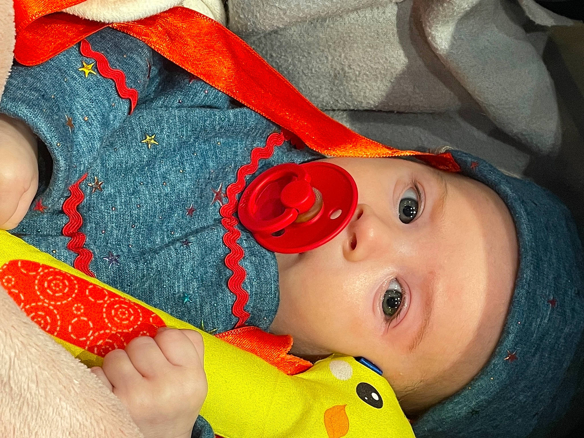 Luna a rejoint le concours — aidez-le/la à gagner de superbes lots ! baby, baby_toddler_clothing, cheek, child, close_up, eyelash, gesture, happy, hat, headwear, lip, mouth, nail, nose, orange, person, product, red, skin, sleeve