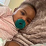 Amani is registered to the contest to win money with this photo: baby, pacifier, pink_clothing, heart_pattern, blanket, fuzzy_texture, close_up, indoor, child, face, sleepy, soft, resting, comfort, toddler, cute, infant, young_child, person, portrait