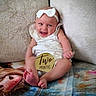 baby, infant, child, smiling, portrait, sitting, bow, headband, dress, milestone, two_months, wooden_sign, couch, pillow, blanket, indoor, colorful, happy, feet, photography