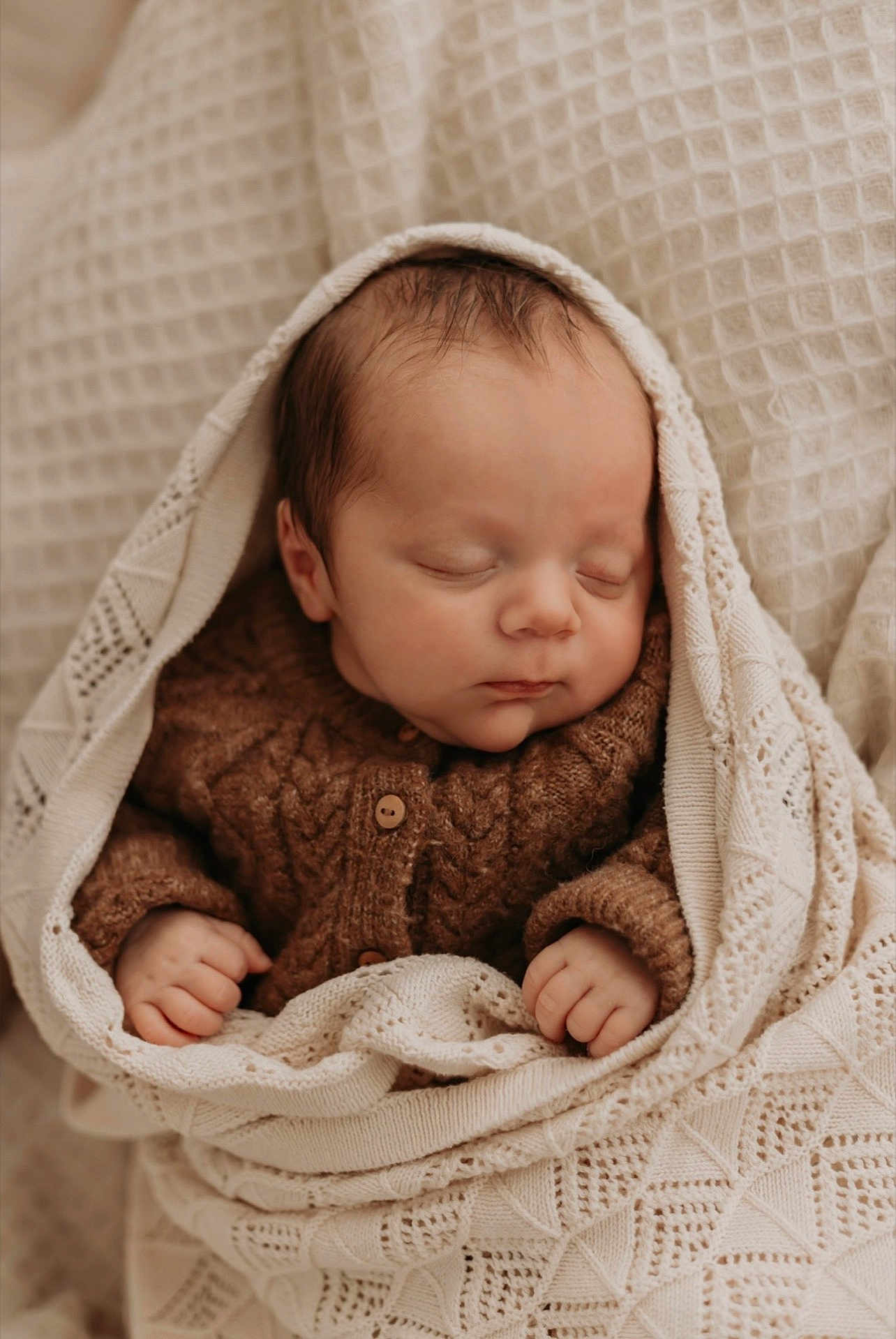 Gabin a rejoint le concours — aidez-le/la à gagner de superbes lots ! baby, newborn, sleeping, blanket, knitted, brown_sweater, cozy, wrapped, infant, peaceful, cute, portrait, soft_light, hands, face, closed_eyes, warm, texture, cuddle, indoors