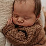 Gabin a rejoint le concours — aidez-le/la à gagner de superbes lots ! baby, sleeping, infant, knitted_sweater, brown_clothing, cozy, soft_texture, blanket, close_up, peaceful, cute, child, portrait, warm_colors, face, head, resting, indoors, newborn, tiny_hand