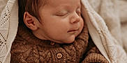 Gabin a rejoint le concours — aidez-le/la à gagner de superbes lots ! baby, sleeping, knitted_sweater, brown_clothing, blanket, cozy, infant, peaceful, close_up, soft_light, portrait, newborn, cute, warm, child, face, hand, indoor, relaxation, comfort