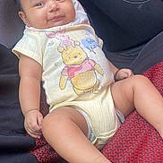 Yunuen is registered to the contest to win money with this photo: baby, child, infant, smile, winnie_the_pooh, piglet, onesie, clothing, seat, car_interior, red_pattern, black_fabric, cute, happy, portrait, skin, foot, hand, face, person