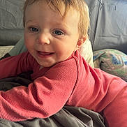Aubrey is registered to the contest to win money with this photo: baby, blanket, bodypart, clothing, couch, cushion, face, finger, furniture, hand, happy, head, homedecor, knitwear, pants, person, photography, portrait, smile, sweater