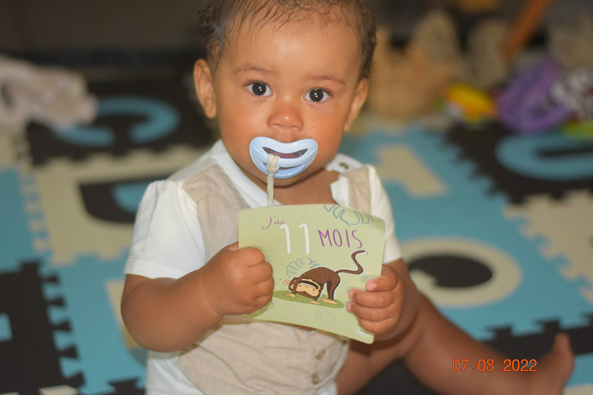 Kidane participe au concours pour gagner de l'argent avec cette photo : adaptation, baby, baby_food, baby_toddler_clothing, cheek, child, eating, finger, fun, gesture, hand, happy, nail, person, play, room, sitting, smile, t_shirt, thumb