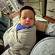 Laith joined the competition — help win amazing prizes! baby, bedroom, bracelet, clothing, dresser, face, floor, furniture, hand, head, indoors, infant, jewelry, mirror, person, portrait, rug, swaddle, wooden_floor, wrapped