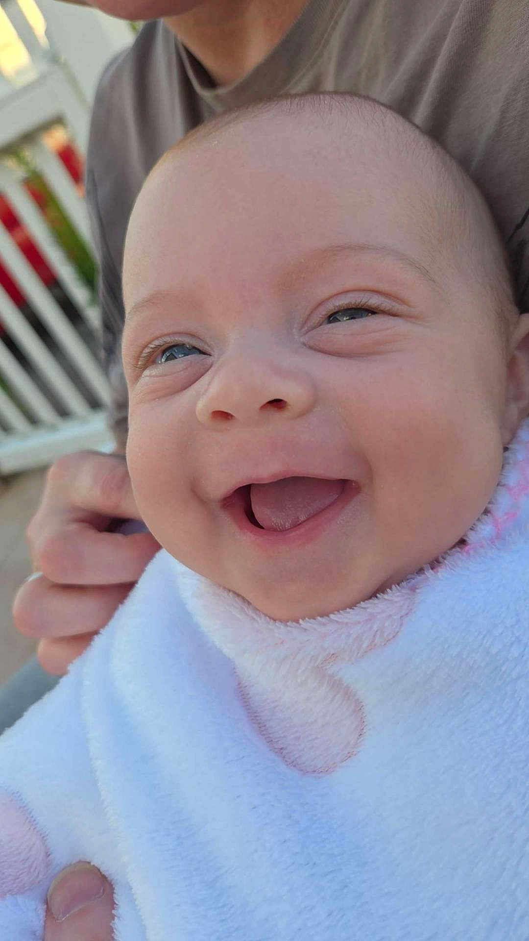 Aria participe au concours pour gagner de l'argent avec cette photo : apparel, baby, blanket, casual_clothing, child, closeup, expression, face, hand, happy, head, holding, human, infant, joy, outdoor, person, portrait, skin, smile