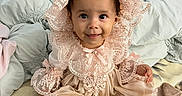 Aliana is registered to the contest to win money with this photo: baby, bed, blanket, bonnet, child, clothing, cute, dress, face, happy, home, indoors, infant, lace, person, pillow, pink, portrait, sitting, smile