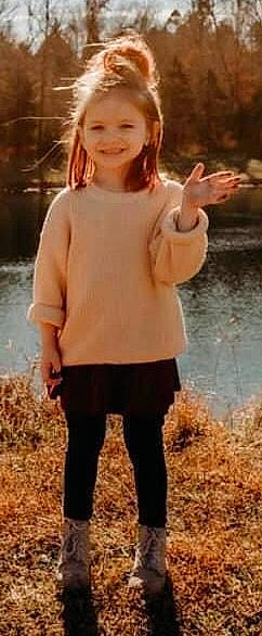 Paisley is registered to the contest to win money with this photo: beauty, blond, child, gesture, grass, happy, joy, lake, long_hair, natural_landscape, people_in_nature, person, photograph, plant, sleeve, smile, t_shirt, thigh, toddler, water