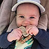 baby, infant, cap, pacifier, smile, blue_eyes, clothing, sweater, wooden_beads, stroller, cushion, child, cute, happy, hand, face, portrait, outdoor, person, baby_accessory