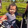 toddler, child, smiling, outdoor, grass, blanket, curly_hair, sunny, blue_sky, stroller, chair, toy, playing, happy, person, daylight, casual_clothing, reaching_out, park, nature