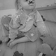 Chlélya participe au concours pour gagner de l'argent avec cette photo : toddler, child, pajamas, toy, stuffed_animal, floor, indoor, face_filter, dog_filter, butterfly, black_and_white, cute, sitting, playful, expression, wooden_floor, casual, childhood, cozy, home