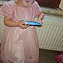 Chlélya participe au concours pour gagner de l'argent avec cette photo : child, girl, pink_dress, smartphone, indoor, window, raindrops, floor, radiator, entertainment, technology, screen, curly_hair, casual, standing, young, focused, modern, cute, play