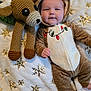 Bentley joined the competition — help win amazing prizes! baby, child, onesie, reindeer_costume, plush_toy, crocheted_toy, blanket, snowflake_pattern, holiday_theme, cozy, cute, smiling, infant, indoors, soft_texture, face, hand, foot, sleepwear, festive