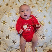 Bentley is registered to the contest to win money with this photo: baby, infant, red_onesie, christmas, holiday, blanket, snowflake_pattern, golden_sparkles, cute, smiling, lying_down, indoors, festive, celebration, child, person, soft_texture, holiday_outfit, christmas_theme, happy
