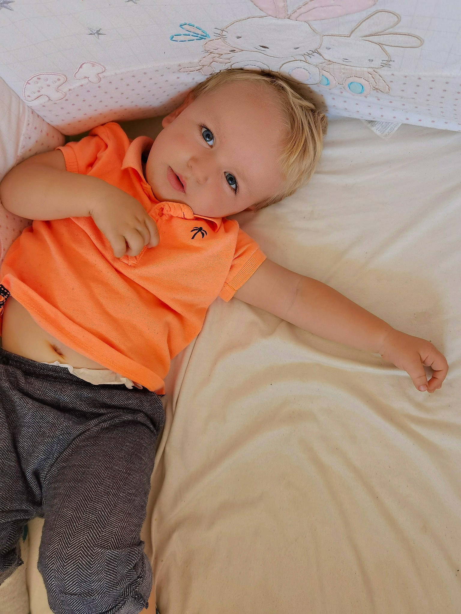 Luiz participe au concours pour gagner de l'argent avec cette photo : abdomen, baby, baby_toddler_clothing, bedding, cheek, child, comfort, eye, happy, human_leg, iris, linens, pattern, person, pink, portrait_photography, room, sitting, skin, smile