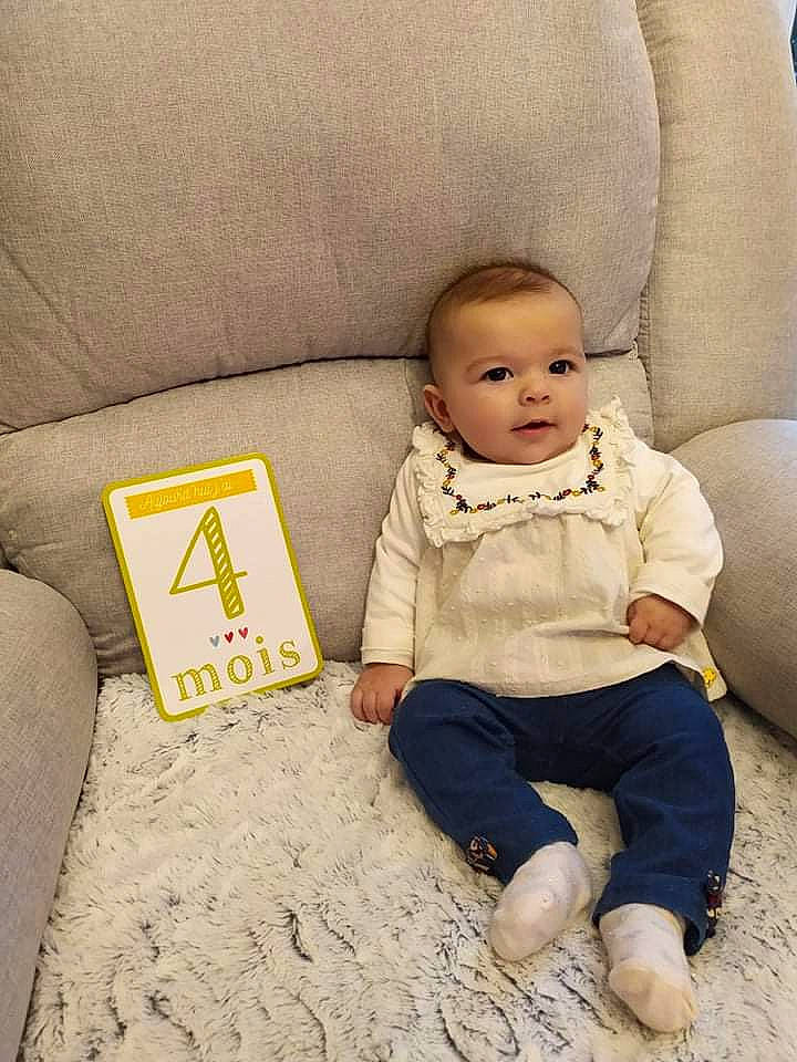 Siena participe au concours pour gagner de l'argent avec cette photo : baby, baby_toddler_clothing, beige, comfort, couch, eye, face, facial_expression, floor, flooring, hairstyle, happy, head, headgear, person, skin, sleeve, smile, textile, vertebrate